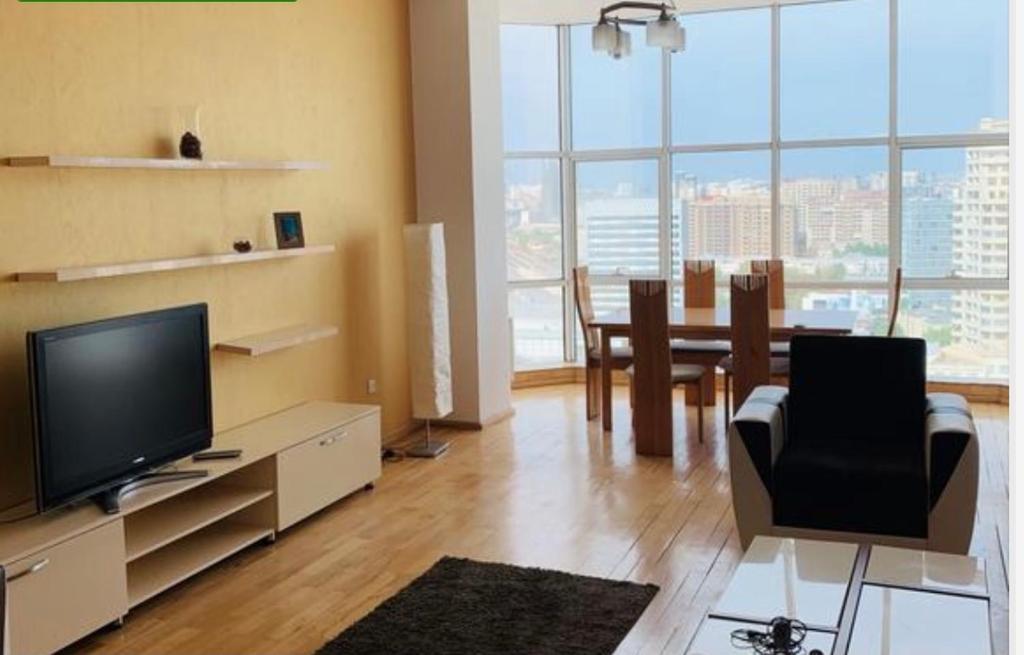 a living room with a television and a dining room at BEST VIEW APARTMENT WITH TERRACE in Baku