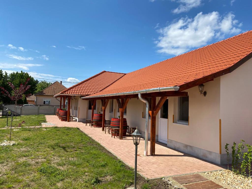dom z czerwonym dachem i krzesłami w obiekcie Tisza-i Apartmanok w mieście Tiszafüred
