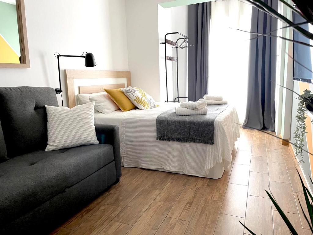 a bedroom with a bed and a couch at Barcelona COZY Apartment in Hospitalet de Llobregat