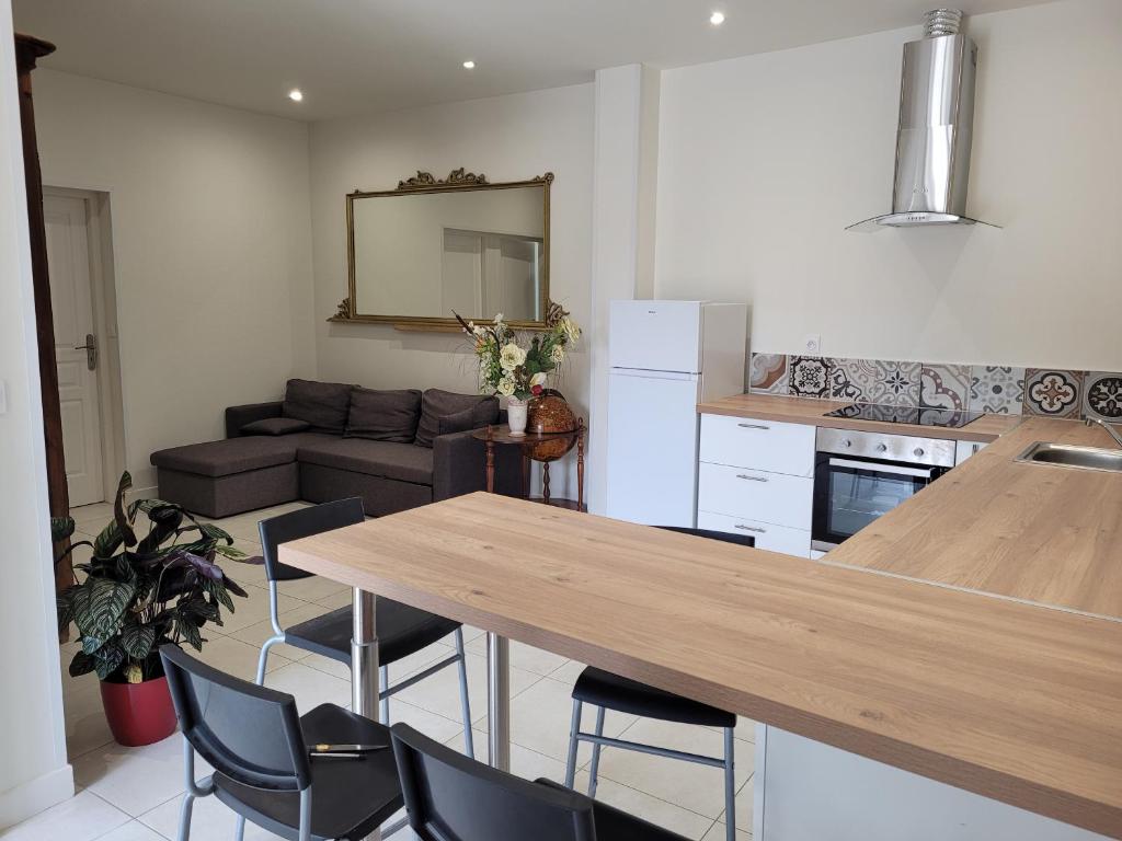 a kitchen and living room with a table and chairs at UN AIR DE VACANCES in Layrac