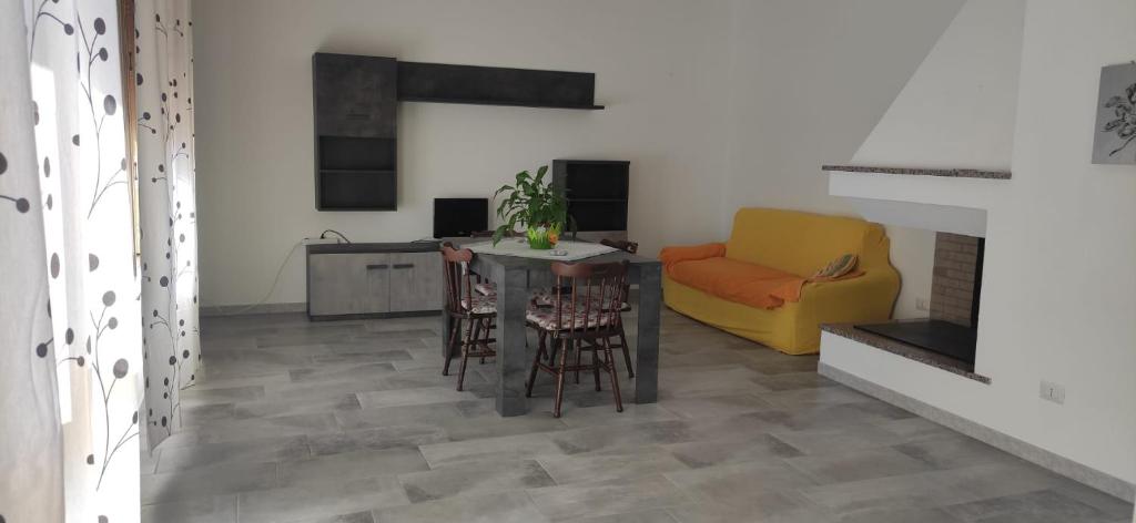 - un salon avec une table et un canapé jaune dans l'établissement Appartamento Monte Argentu, à Fluminimaggiore