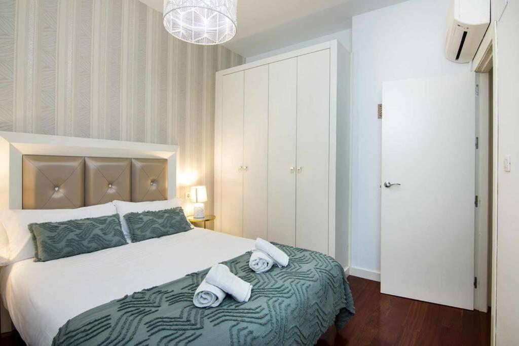 una camera da letto con un letto e due asciugamani di ECO CENTER GRANATENSIS CATEDRAL 2 habitaciones free párking a Granada