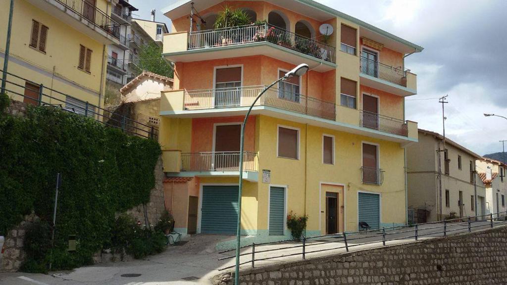 un edificio giallo e arancione con balcone di L'EDERA a Osini