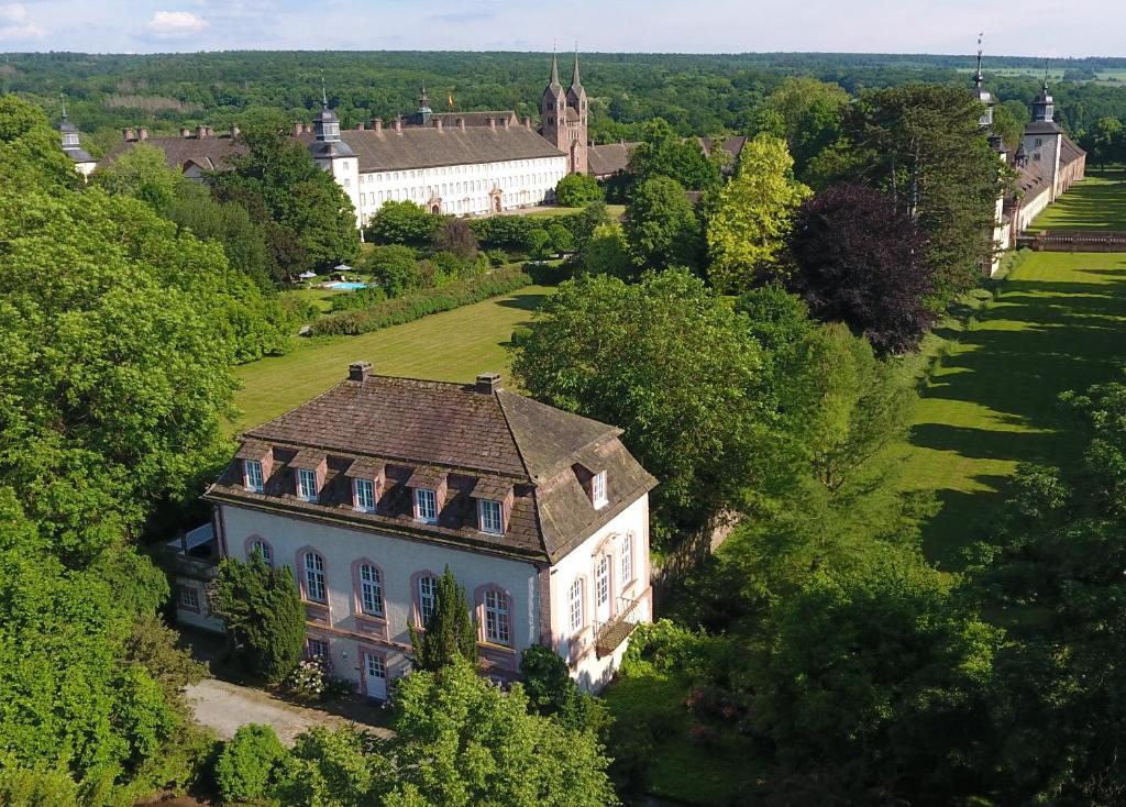 eine Luftansicht eines großen Hauses auf einem Feld in der Unterkunft Teehaus im Schlosspark Weltkulturerbe Corvey in Höxter