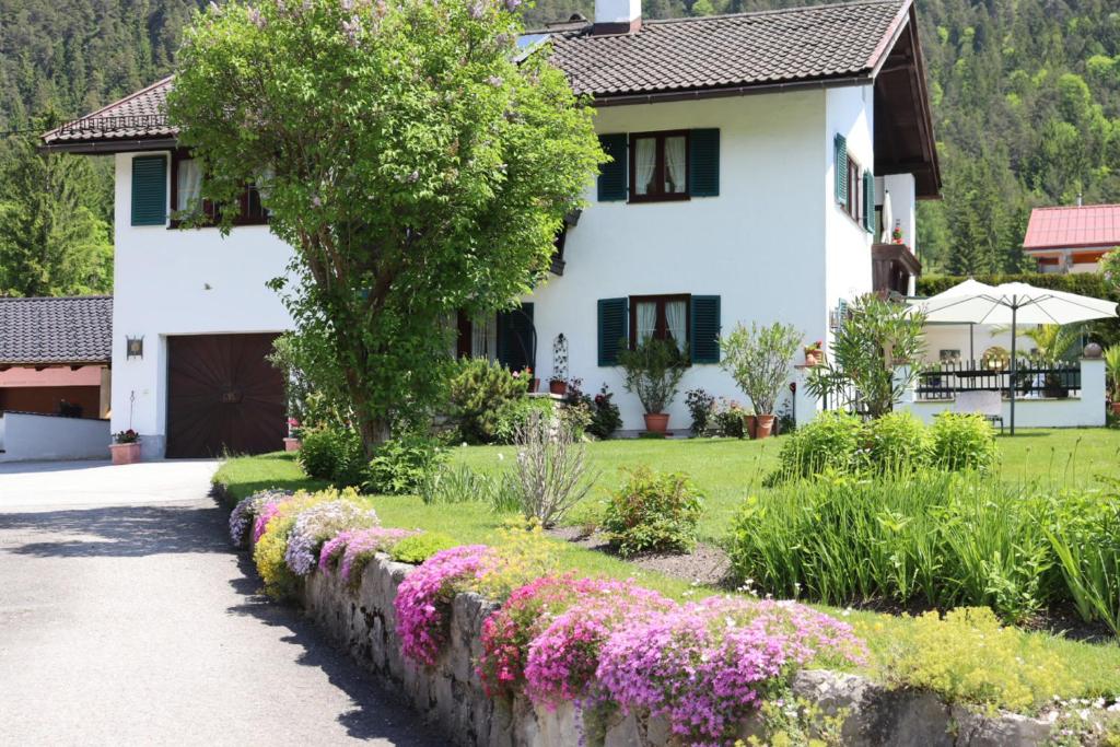 a house with flowers in front of a yard at Haus Moderegger in Bischofswiesen