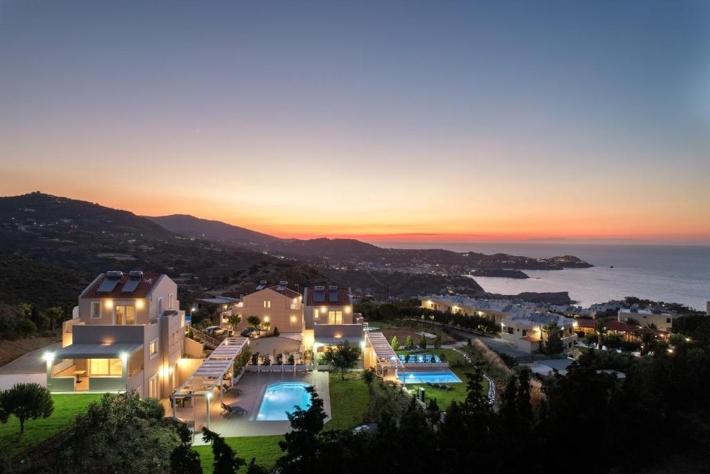 a villa with a view of the ocean at sunset at Blue Hills Villas in Agia Pelagia