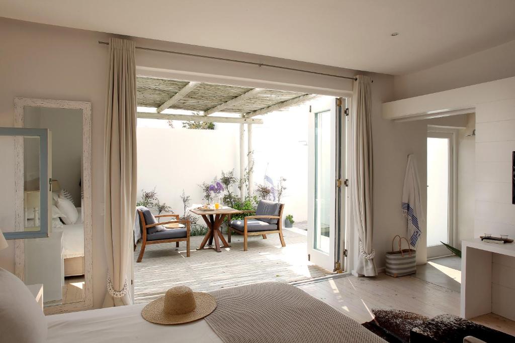 a bedroom with a door open to a patio at Strandloper Ocean Boutique Hotel in Paternoster