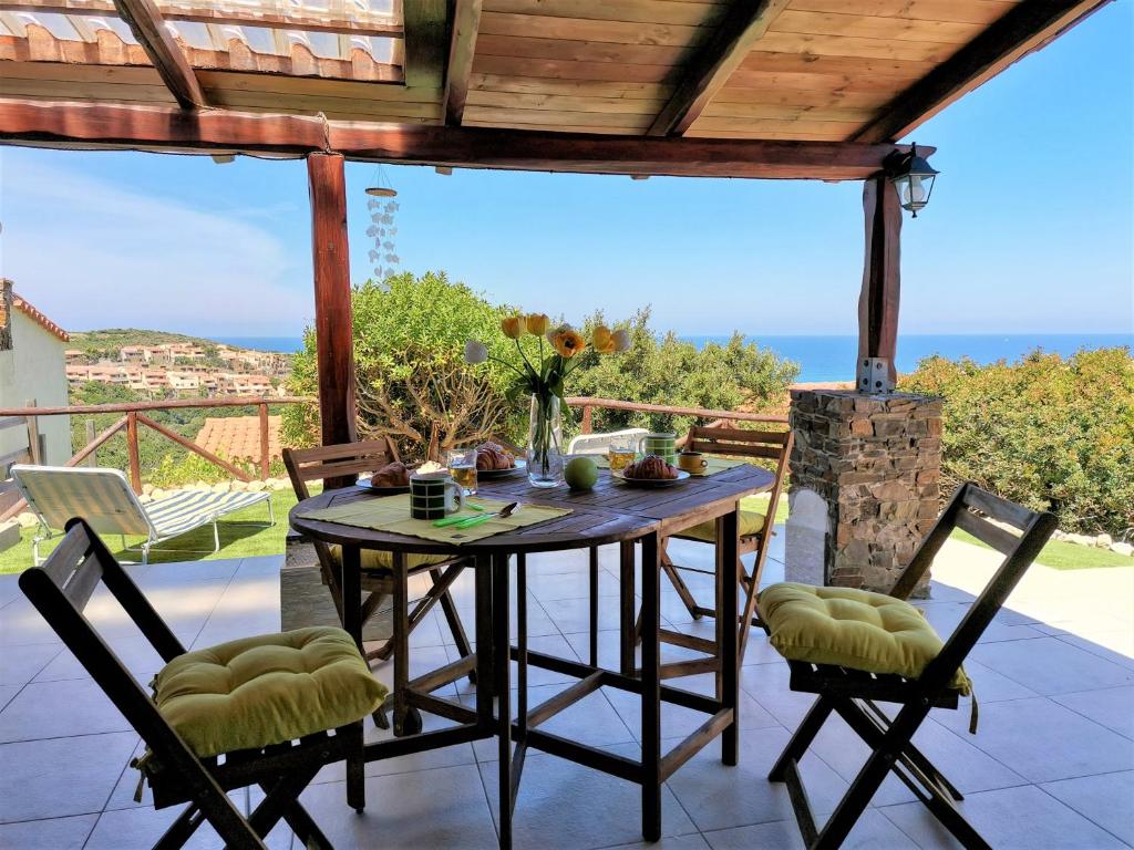 een tafel en stoelen op een patio met uitzicht op de oceaan bij Oro Tramonto in Torre Dei Corsari