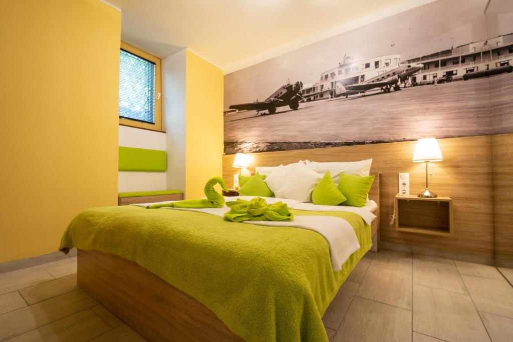 ブダペストにあるCastle Suiteのベッドルーム1室(緑のシーツが敷かれたベッド1台、壁に絵画付)