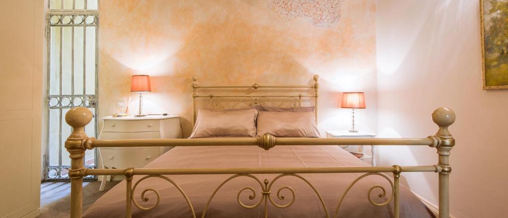 フィレンツェにあるApartments Florence Ghibellina Balconyのベッドルーム1室(ベッド1台、ランプ2つ、テーブル2台付)