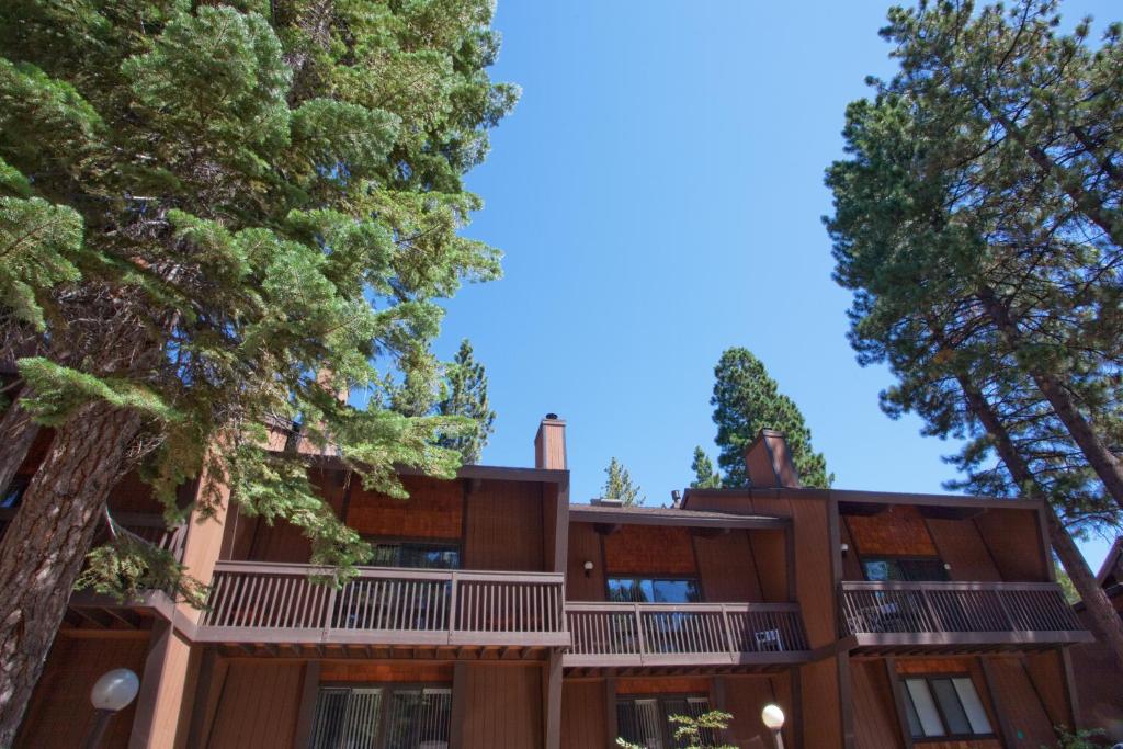 un edificio de apartamentos con árboles en el primer plano en Club Tahoe Resort, en Incline Village
