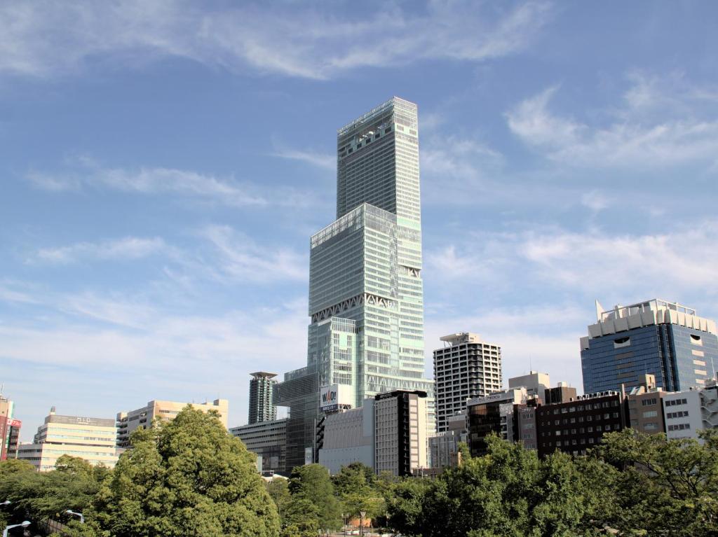 un grand bâtiment en verre dans une ville arborée dans l'établissement Osaka Marriott Miyako Hotel, à Osaka