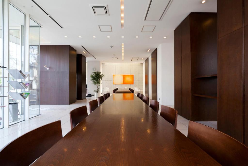 une longue salle de conférence avec une grande table et des chaises dans l'établissement 7 Days Hotel Plus, à Kōchi