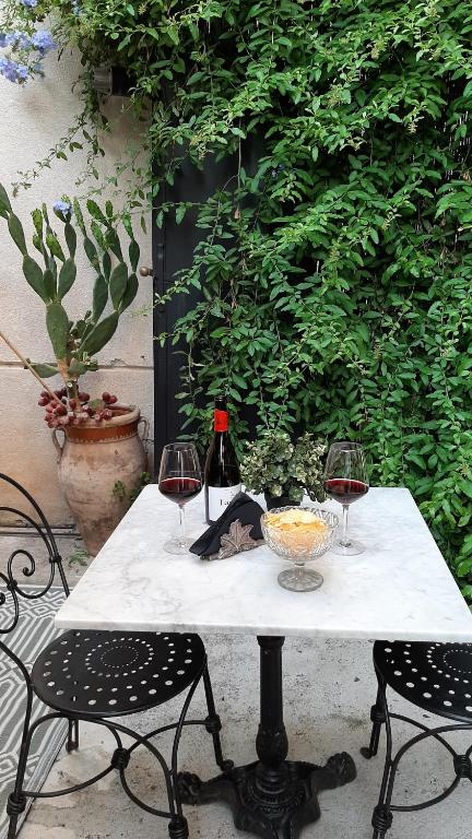 a table with two glasses of wine and two chairs at B&B del Giglio in Cefalù