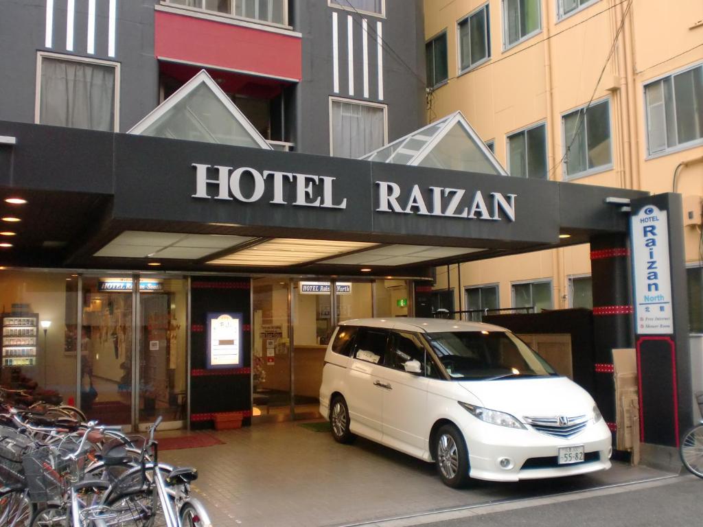 una furgoneta blanca estacionada frente a un hotel rauman en Hotel Raizan North, en Osaka