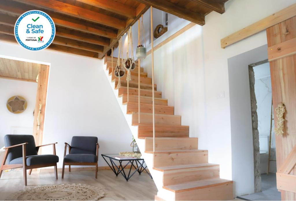 a staircase in a house with two chairs and a table at Sete Cidades Nature Villa in Sete Cidades