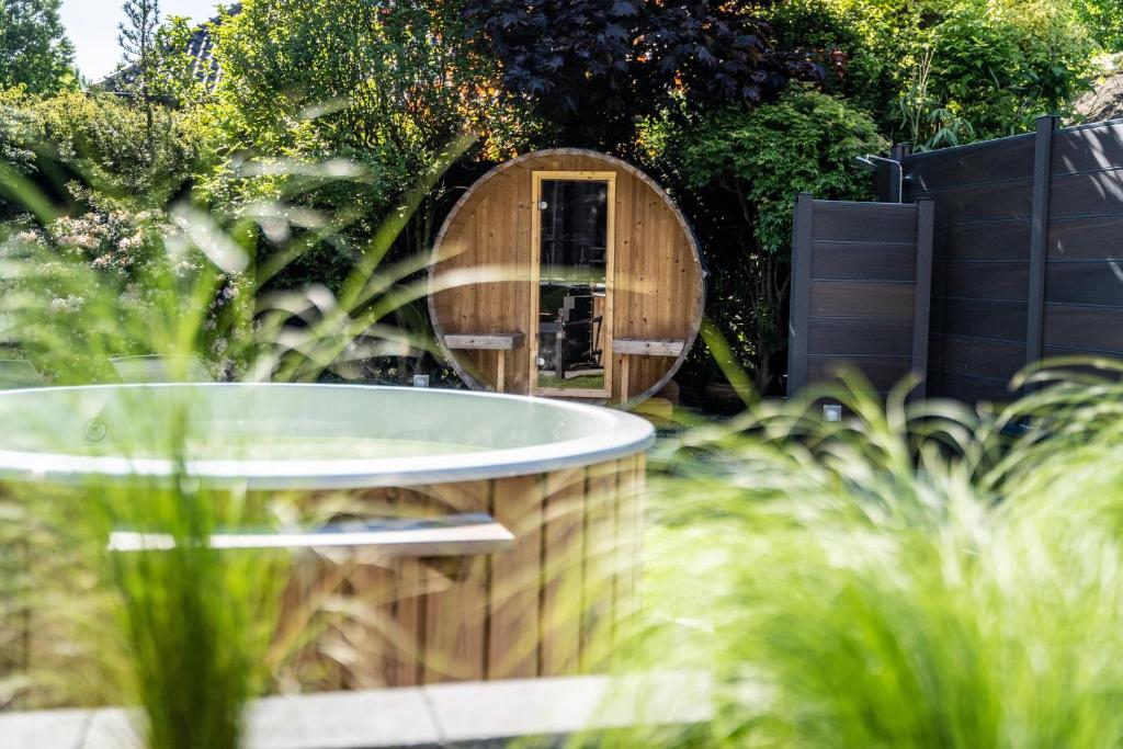 una bañera de madera en un jardín con espejo en hygge Niederrhein en Rees