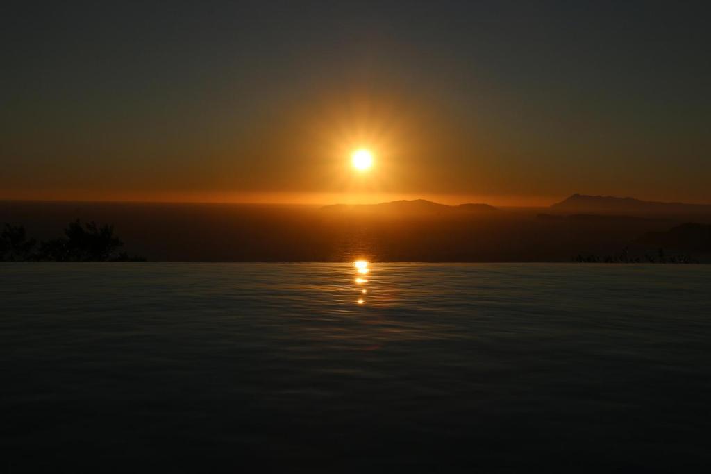 a sunset over a body of water at Sunset Sea View Villa 1 in Agios Georgios