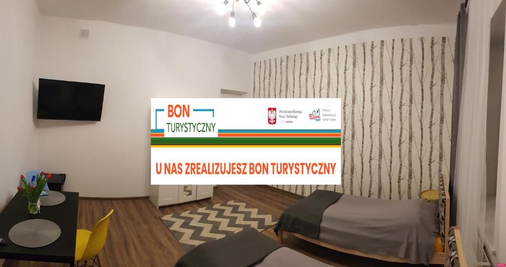 a room with a stage with a bed and a sign at Guest Room RÓWNA in Kielce