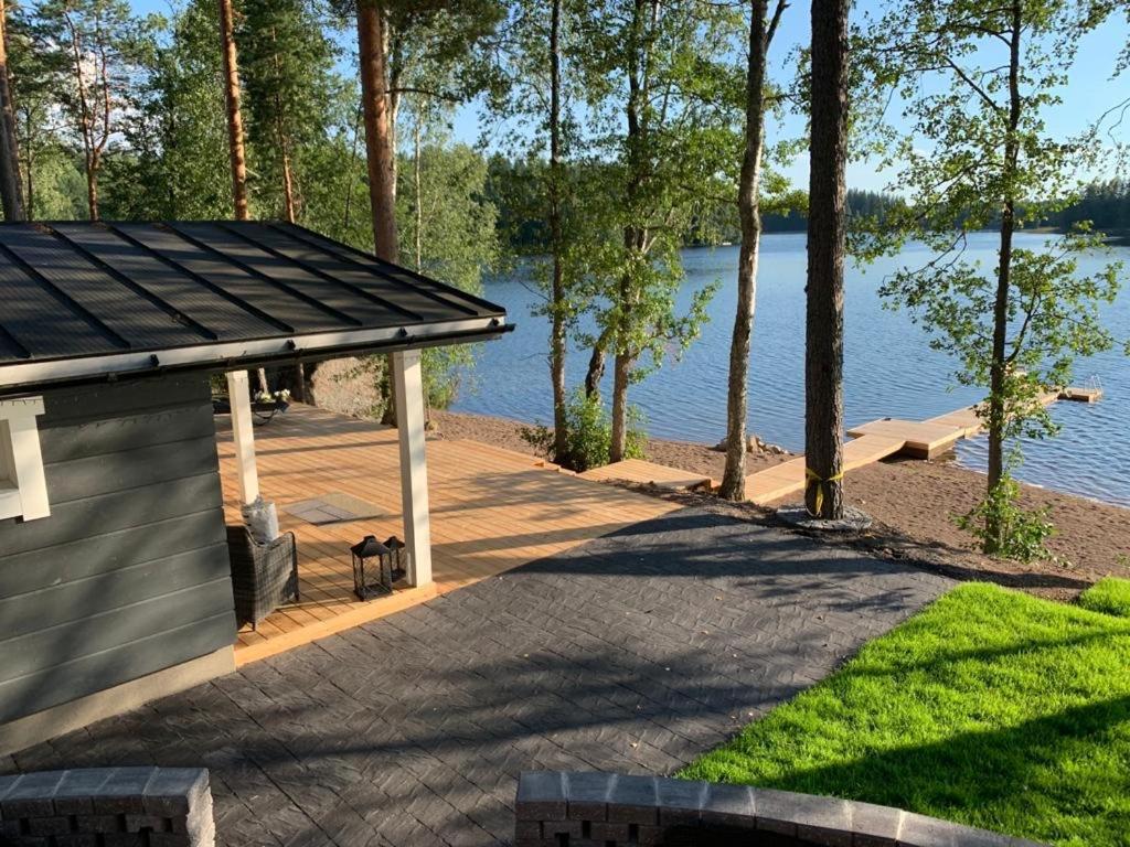 a dock with a gazebo next to a lake at Villa Terveenniemi in Kontula