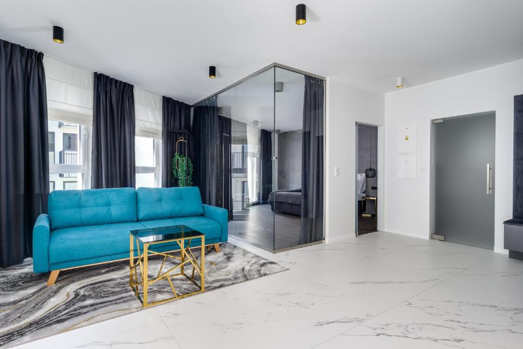 ein Wohnzimmer mit einem blauen Sofa und einem Tisch in der Unterkunft EL Apartments - Lupus in Posen