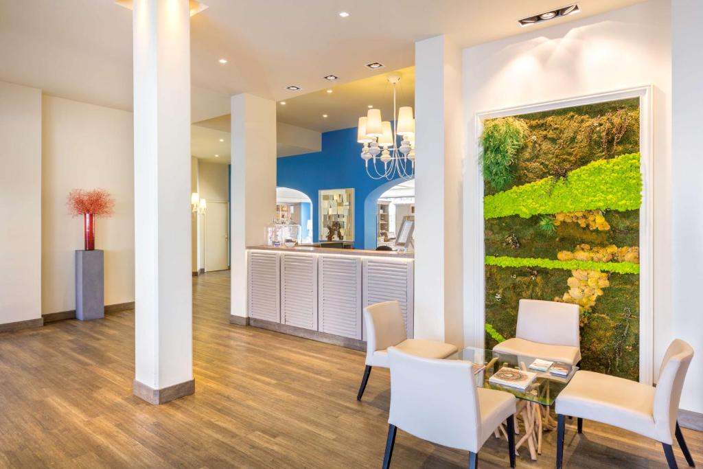 a dining room with a large painting on the wall at Best Western Hotel Matisse in Sainte-Maxime