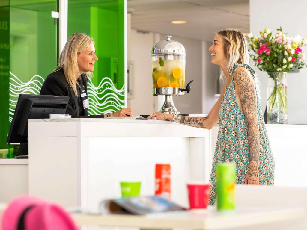 マントンにあるIbis Styles Menton Centreの店のカウンターに立つ二人