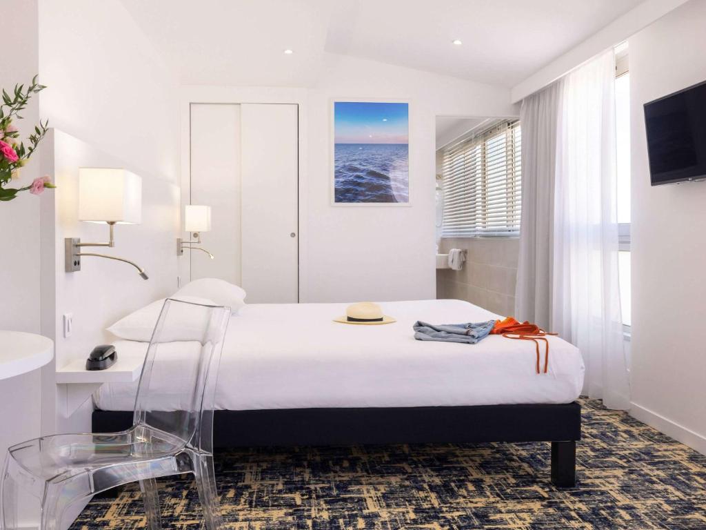a hotel room with a bed and a view of the ocean at Ibis Styles Menton Centre in Menton