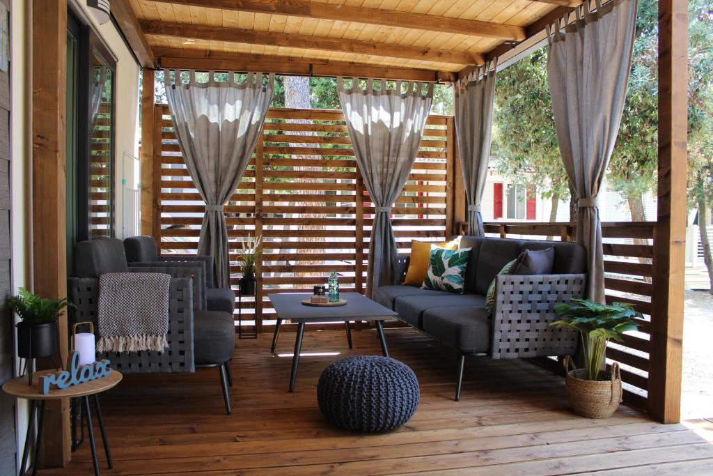 a screened in porch with a couch and a table at Two Sisters mobile home in Biograd na Moru