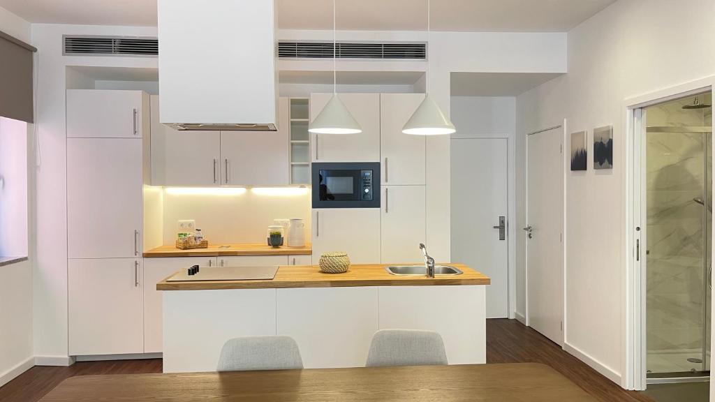 a kitchen with white cabinets and a sink at MyTrip Porto in Matosinhos