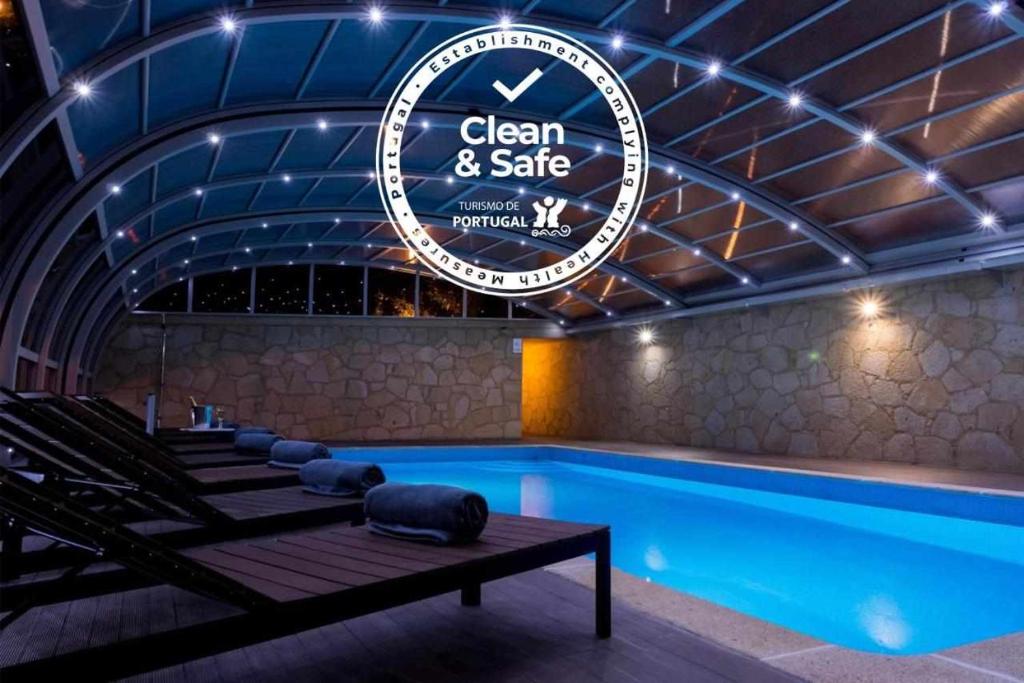 a swimming pool with a sign that reads clean and safe at Casa do Paraíso in Gemieira