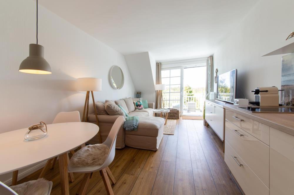 a kitchen and living room with a table and a couch at Ferienwohnung Kleine Strandkoje in Haffkrug