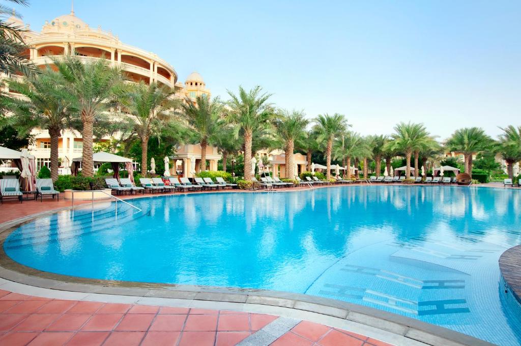 a large swimming pool in front of a resort at Kempinski Hotel Palm Jumeirah in Dubai