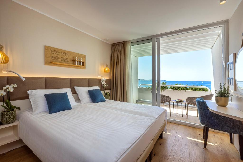 Schlafzimmer mit einem Bett, einem Schreibtisch und einem Fenster in der Unterkunft Hotel Histrion in Portorož