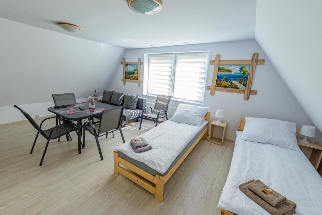 a room with two beds and a table and chairs at Stara Piekarnia - Plac Lotników in Olsztyn