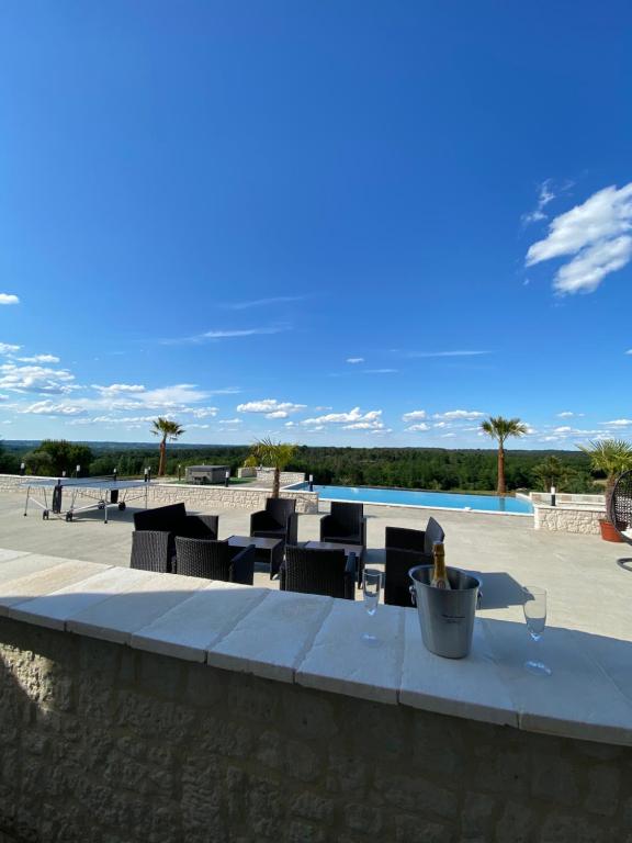 een patio met stoelen en een zwembad bij VILLA DEL CASTAGNOL in Saint-Nexans