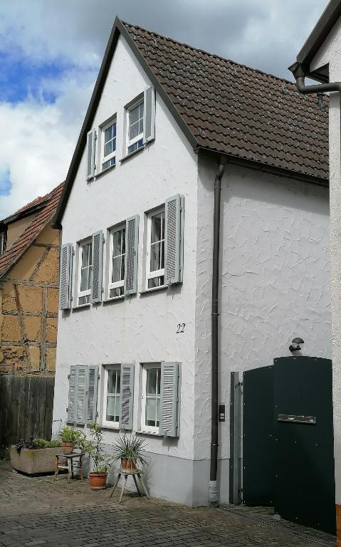 a white house with white windows and a green door at Ferienwohnung Dillamar in Veitshöchheim