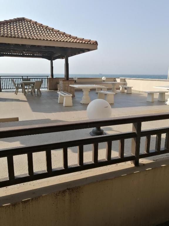 a deck with picnic tables and a pavilion on the beach at norizana's apartment in Westbrook