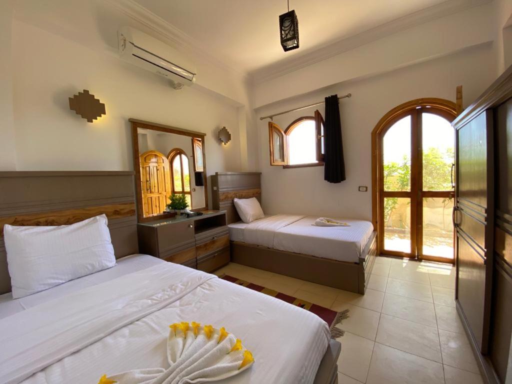 a bedroom with two beds and two windows at Villa 22 in Dahab
