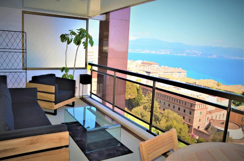 a living room with a balcony with a view of the ocean at Grand T2 STANDING AJACCIO Proche centre et plages VUE PANORAMIQUE PARKING PRIVE in Ajaccio