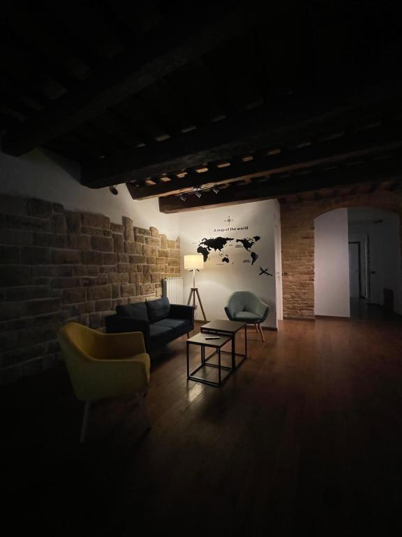 a living room with a couch and chairs and a brick wall at L'ANTICA FALCONERIA in Iesi