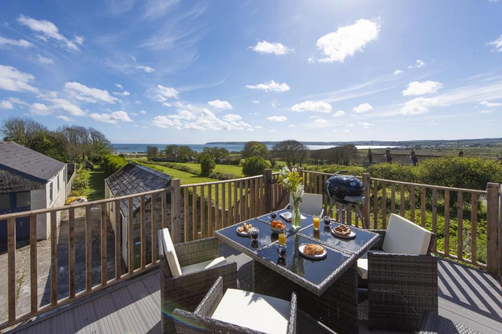 d'une terrasse avec une table et des chaises. dans l'établissement Greenfields Coach House, à Marazion