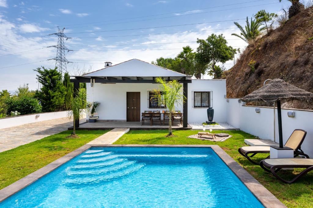 een villa met een zwembad en een huis bij Kanmarala in Alhaurín de la Torre