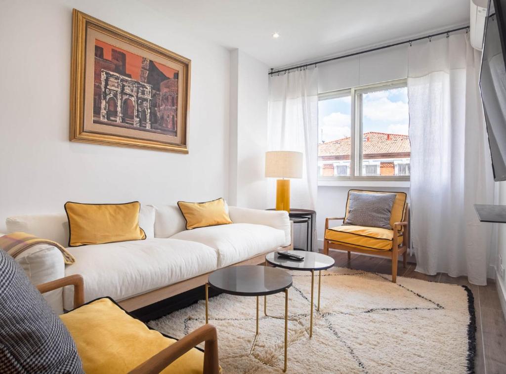 a living room with a white couch and a window at Principe de Vergara I in Madrid