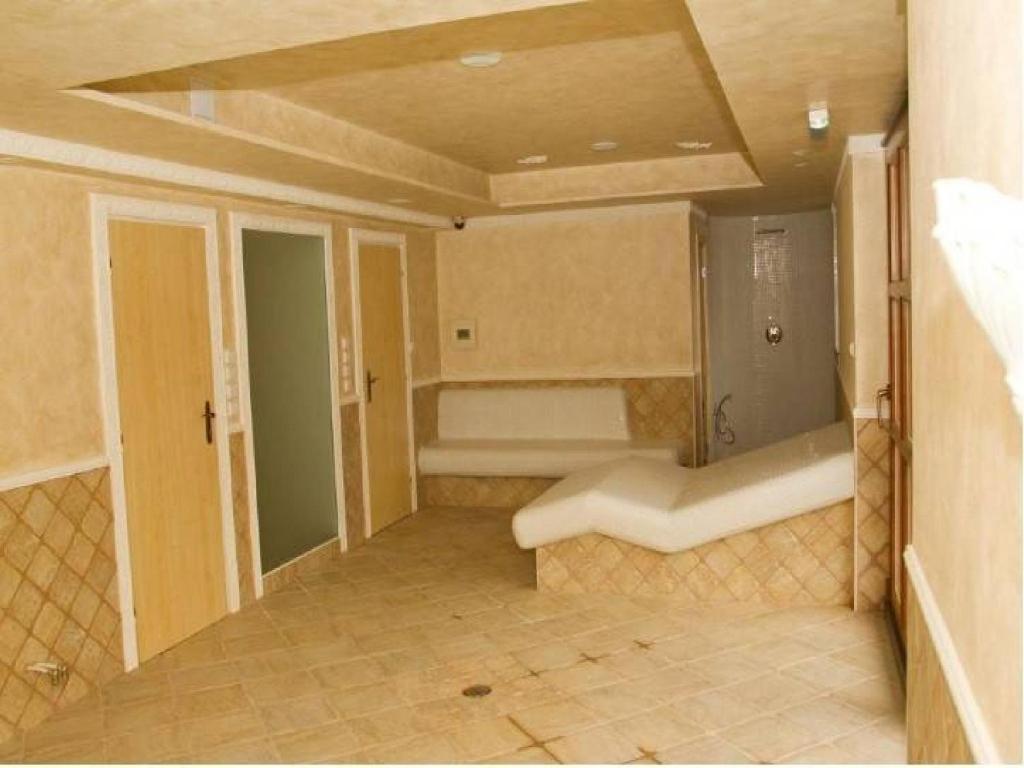 uma casa de banho com banheira e um banco num quarto em Penzion Malovaný em Osvětimany
