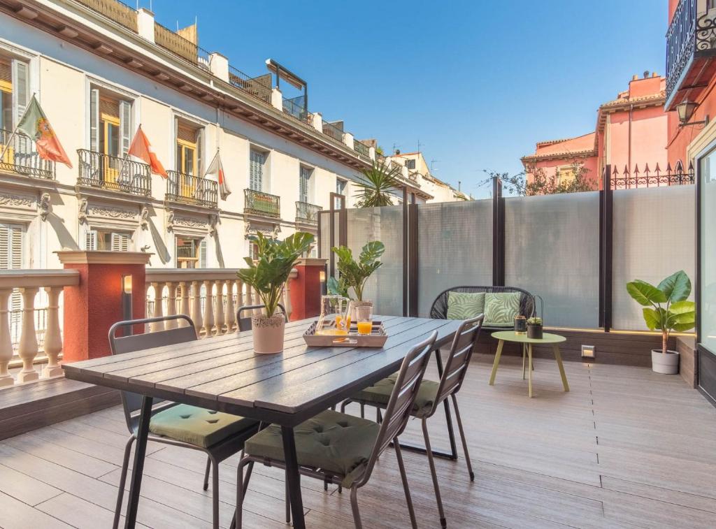 patio con mesa de madera y sillas en el balcón en ESPOZ Y MINA II en Madrid