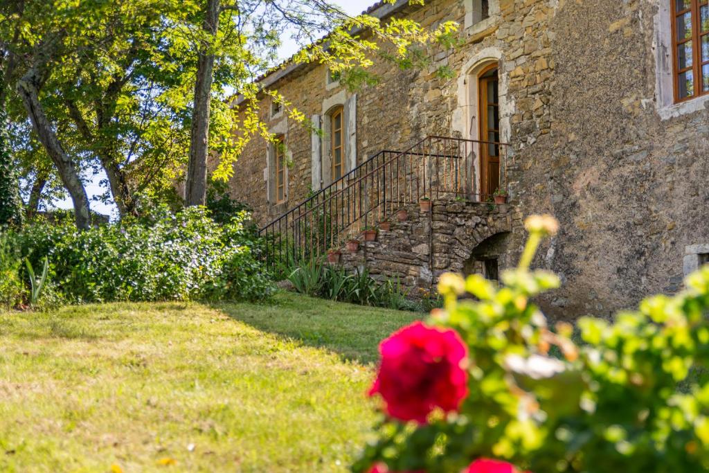 ラゴルスにあるMaison d'Hôtes Mas de la Chadenedeの階段と赤い花の石造りの家