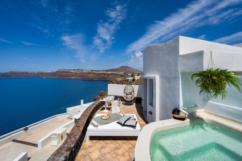 a villa with a swimming pool and a view of the ocean at Epic View Suites in Akrotiri