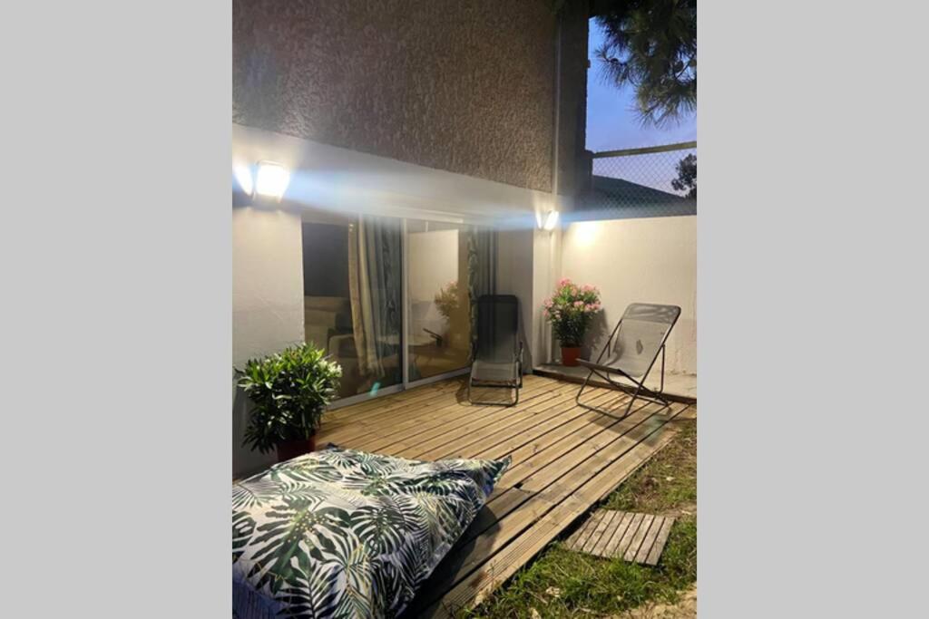 une maison avec une terrasse en bois et un patio dans l'établissement APPARTEMENT studio CAPBRETON SANTOCHA, à Capbreton