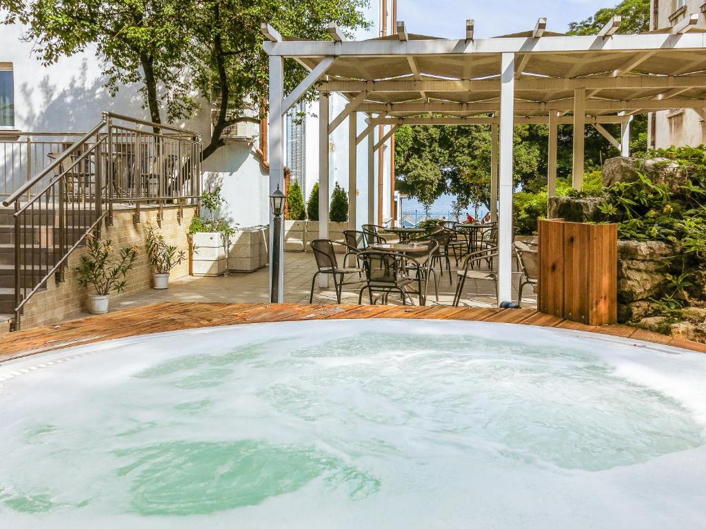a large pool of water in a patio with a table at Family Hotel Belle Epoque Beach in Varna City
